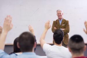male professor standing in front of class