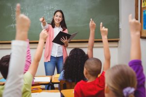 Teacher choosing student to call on with their hand raised to answer a question