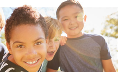 three boys smiling at recess