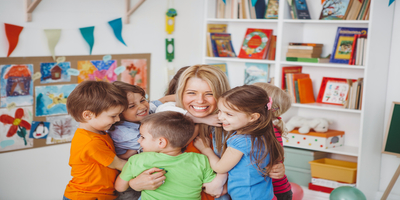 preschool teacher hugging children