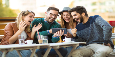 group of people looking at ipad and laughing
