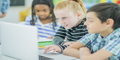 children gathered around a computer