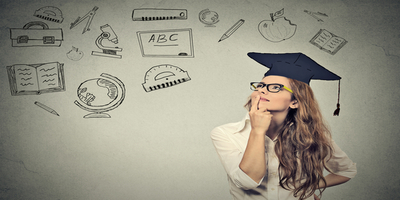 women with graduation cap standing in front of chalkboard
