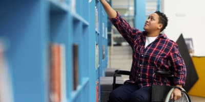 student in wheelchair reaching into his locker