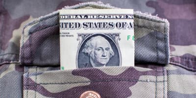 Dollar bill sticking out of camo pocket