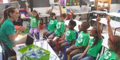 Kids wearing recycling shirts in a classroom