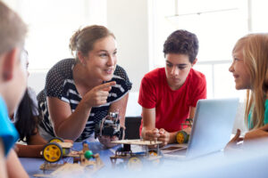 Charter school teacher talking robotics in class students