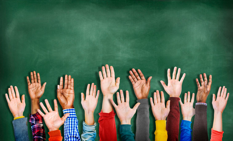 Hands raised in front of chalkboard