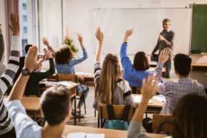 Students with hands raised in class