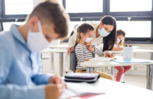 Masked students and teacher in classroom