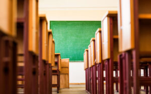 Path between rows of desk and chairs in classroom