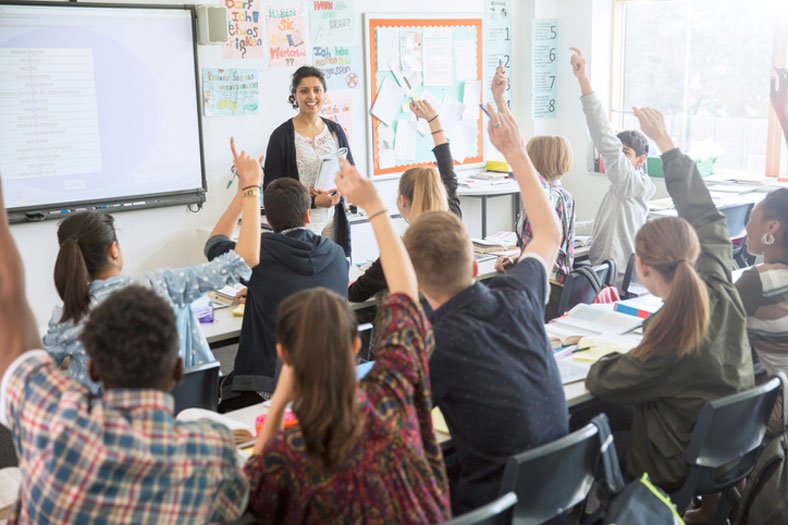 happy teacher in full classroom